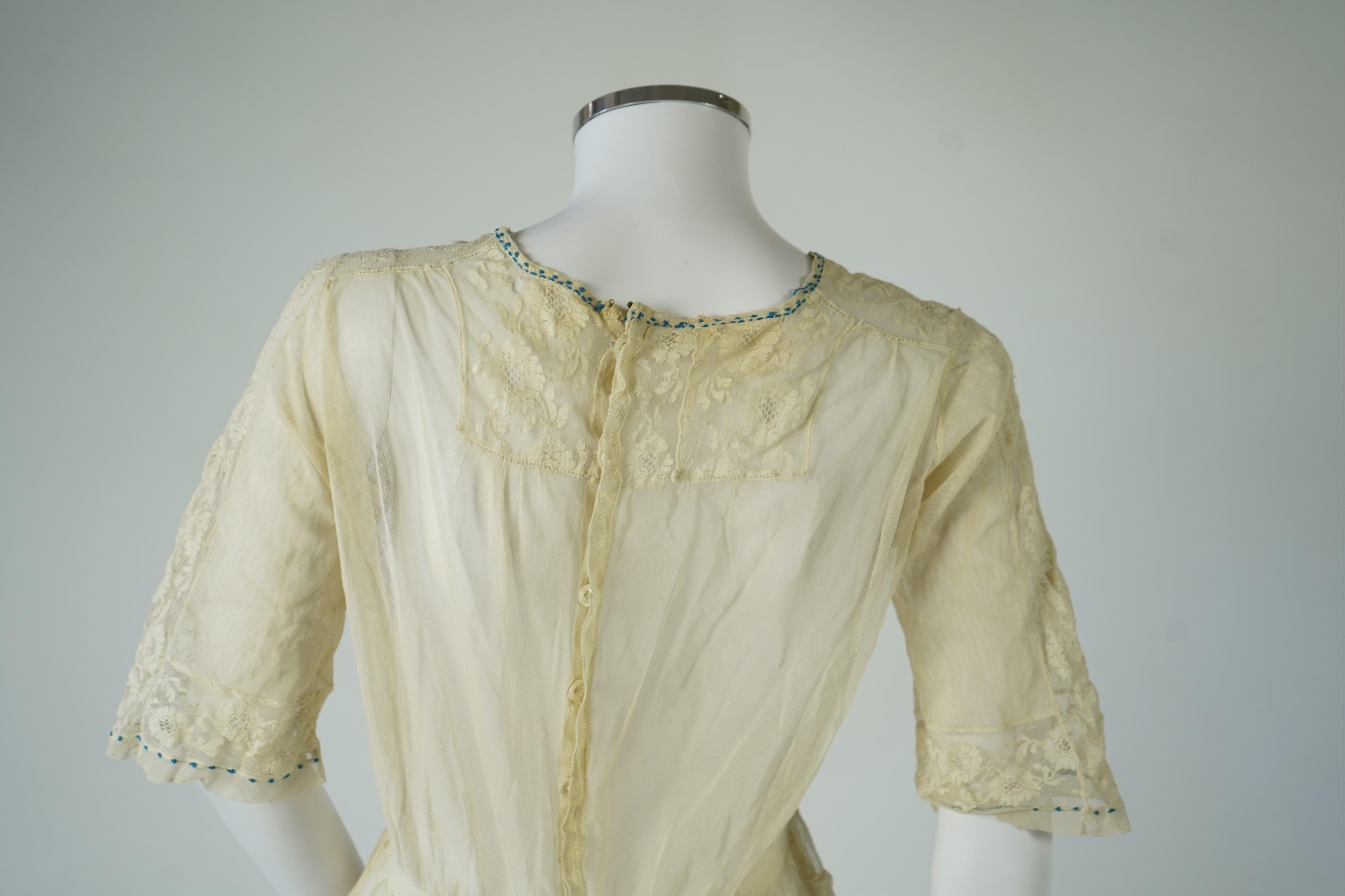 An early 20’s cream net ladies summer dress and net petticoat, designed with a lace inset front skirt, yolk and sleeves.103cm long. Condition - both need re-laundering and some seams tidying.